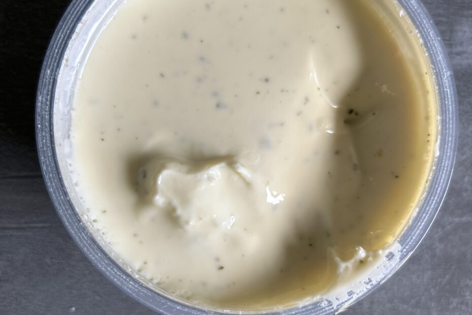 Ein Plastikbecher mit Kochkäse, von oben fotografiert